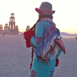 woman carrying penguin backpack at Burning man in Black Rock City